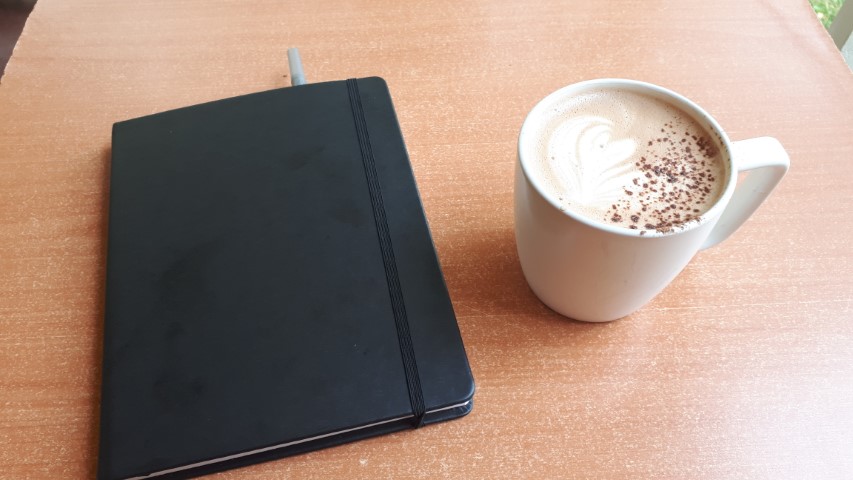 Café et cahier de notes.